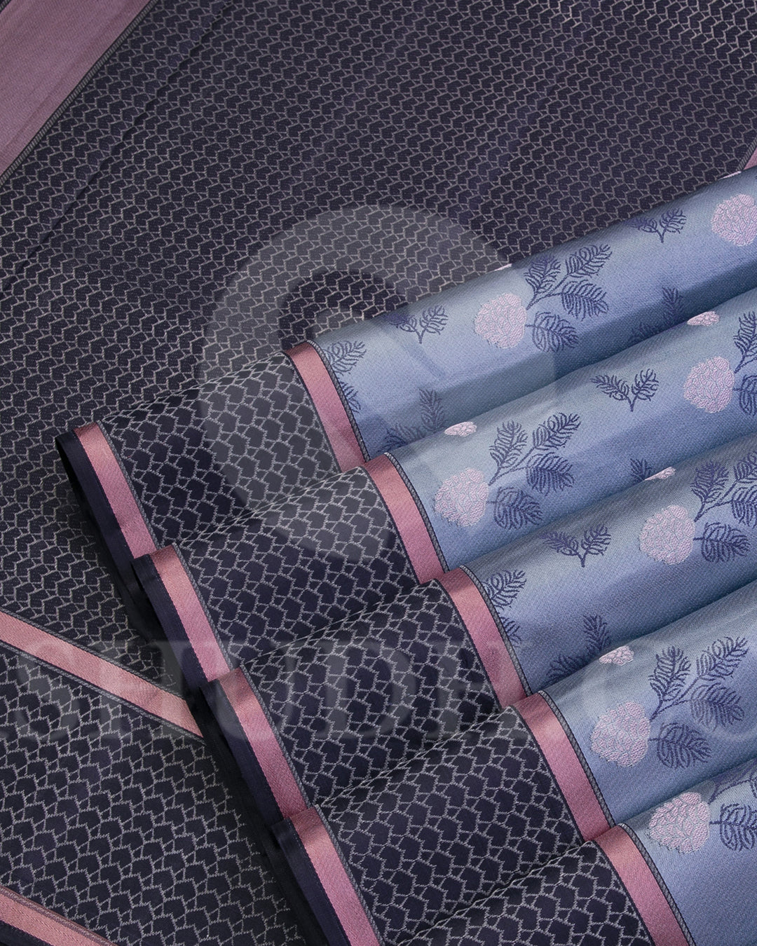 Youthful & Fresh, this Stunning Kanjivaram Silk Saree is out of the ordinary. The pleasing light grey body is adorned with white flowers and dark grey leaves, giving a soft feel, reminding one of japanese art. The complimenting charcoal grey border and pallu features an attractive satin finish and is adorned with a contemporary geometric pattern woven with gold silver zari. The charcoal grey blouse with matching border looks stunning with the light grey, giving a uber cool look in a Saree.