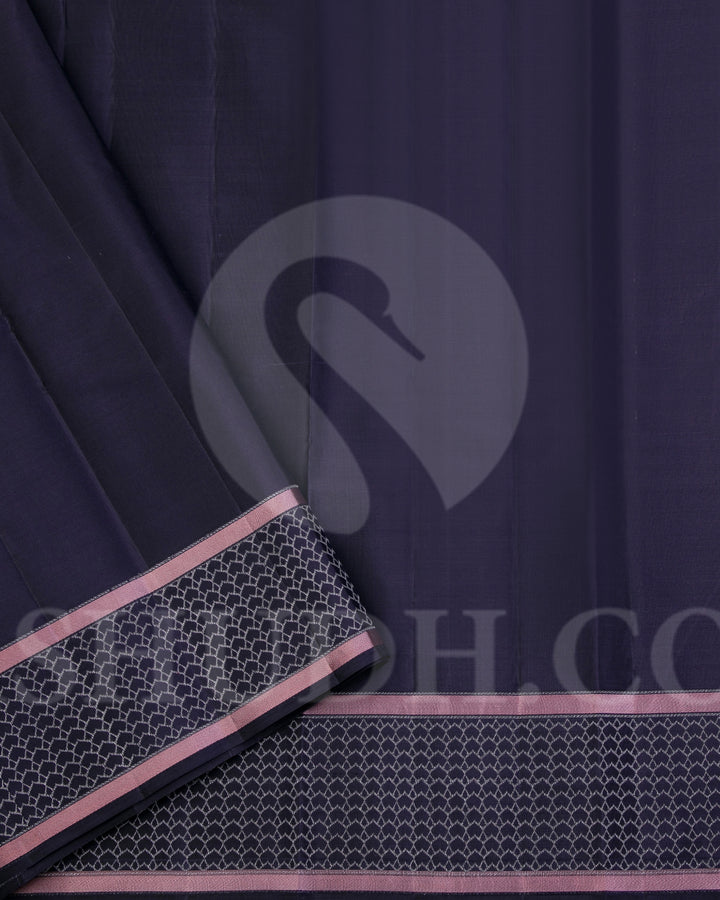 Youthful & Fresh, this Stunning Kanjivaram Silk Saree is out of the ordinary. The pleasing light grey body is adorned with white flowers and dark grey leaves, giving a soft feel, reminding one of japanese art. The complimenting charcoal grey border and pallu features an attractive satin finish and is adorned with a contemporary geometric pattern woven with gold silver zari. The charcoal grey blouse with matching border looks stunning with the light grey, giving a uber cool look in a Saree.